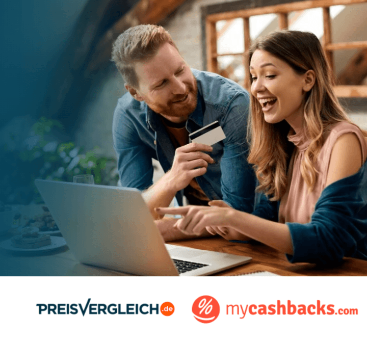 Pärchen lacht vorm Laptop, Mann hält Kreditkarte in der Hand, während Frau auf den Bildschirm zeigt.